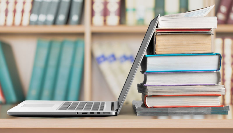 B&auml;rbardator st&aring;r p&aring; ett bord med en trave med b&ouml;cker bakom